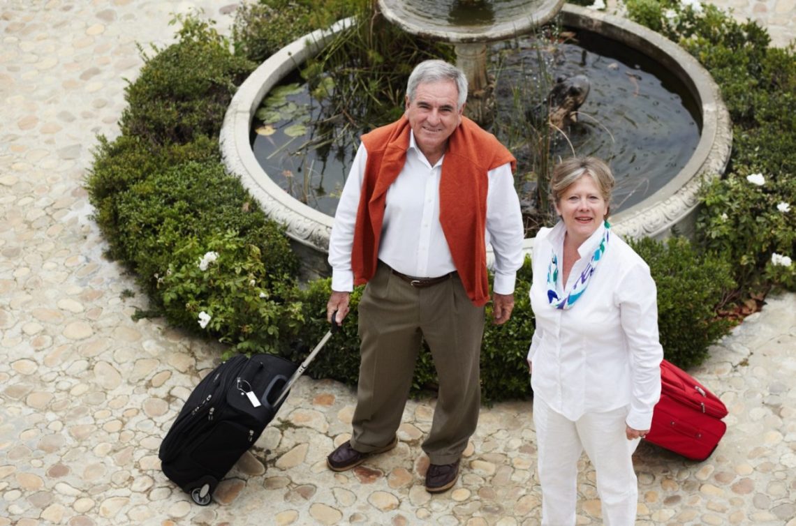 couple agé part en vacances valise à la main